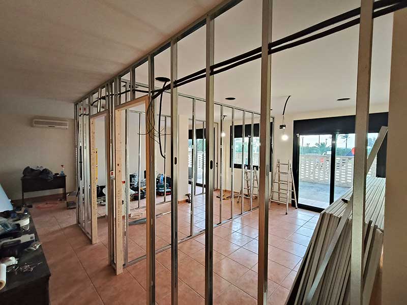 GS Serveis montador de pladur Habitación con estructura metálica y una ventana que permite la entrada de luz natural.