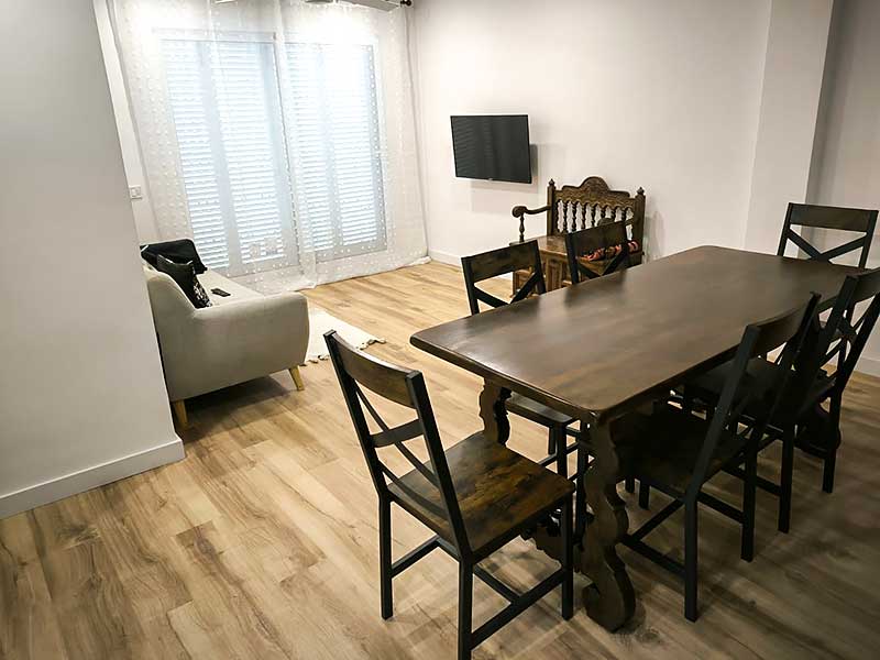 GS-Serveis colocación de parquet salón Un conjunto de mesa y sillas en un espacio interior con suelo de parquet.