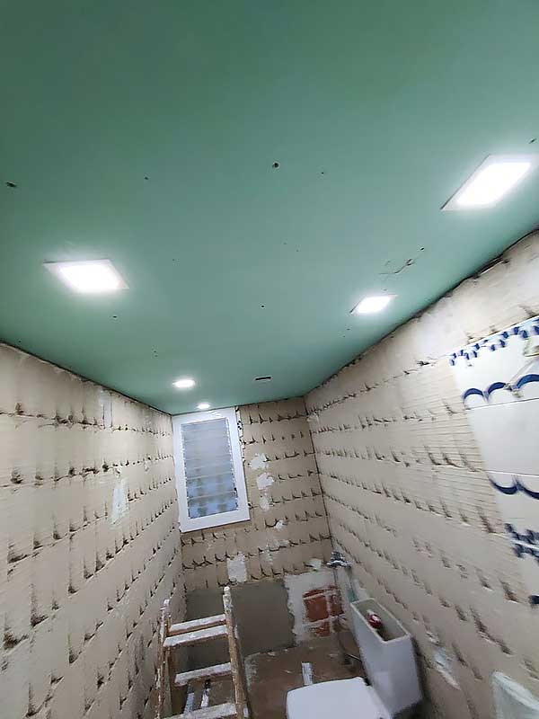 GS-Serveis Trabajo instalación pladur en baño Interior de un baño en obras con el techo color verde.