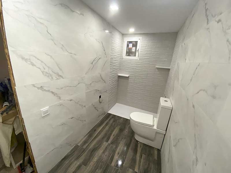 Trabajo instalación pladur baño GS Serveis Interior de un baño en obras con paredes blancas e inodoro blanco.