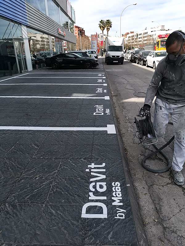 GS Serveis Trabajo de pintura parking Un hombre está aplicando pintura en las plazas de parking, escribiendo la palabra "draivit".