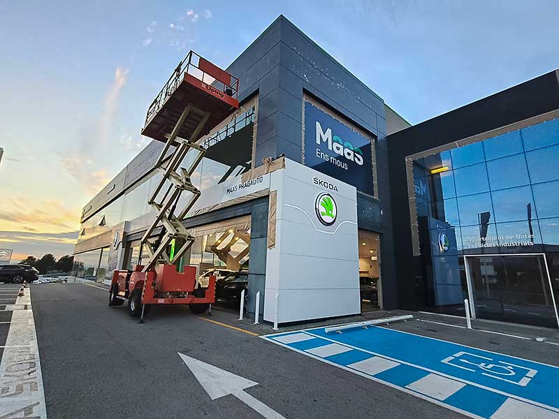 Gs-Serveis Trabajo de pintura Concesionario Maas Un elevador estacionado frente a un edificio, listo para realizar trabajos de mantenimiento.