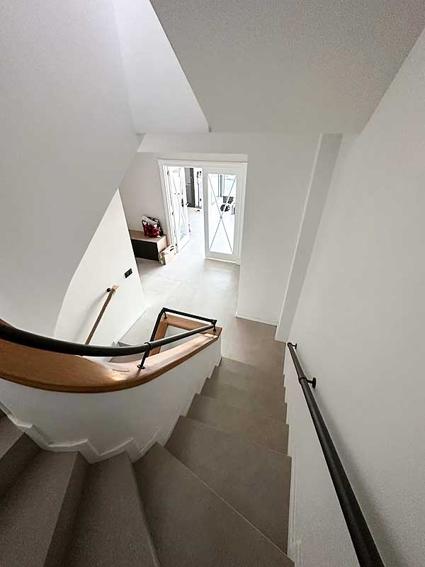 Gs -Serveis Trabajo de pintura de escalera de vivienda Escalera que conduce a una puerta, ofreciendo un diseño minimalista.