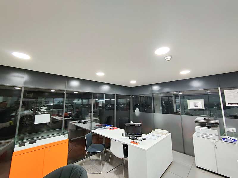 GS-Serveis trabajo de pintura oficinas Gran oficina con abundantes paredes de cristal y numerosos escritorios.